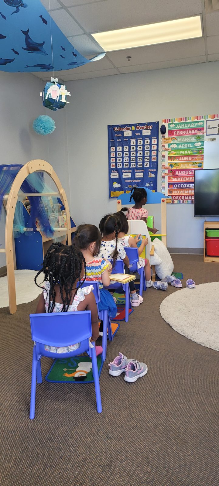 Children at circle time in front of the calendar and weather board
