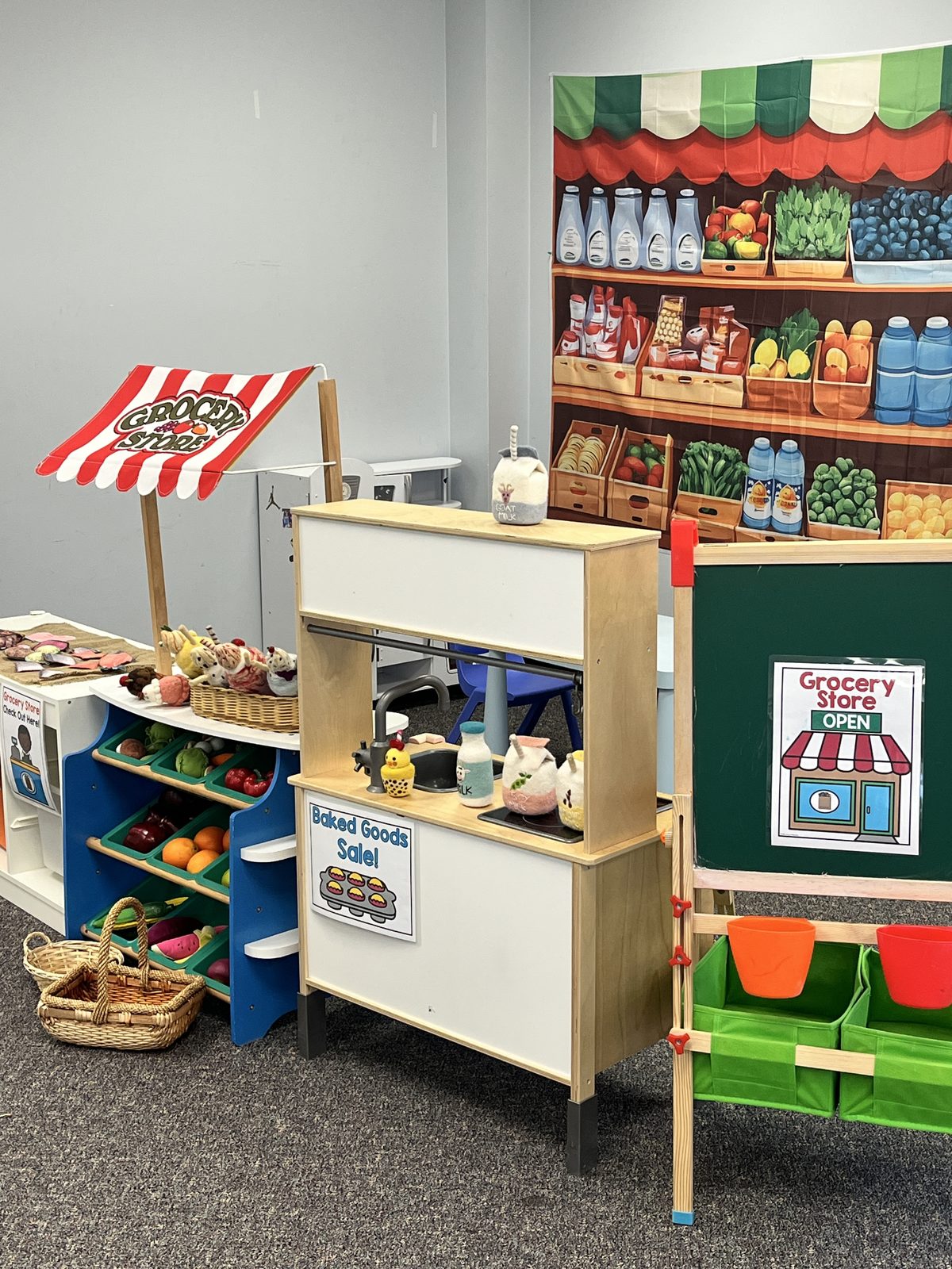 A grocery store dramatic play area with felt produce and a market stall