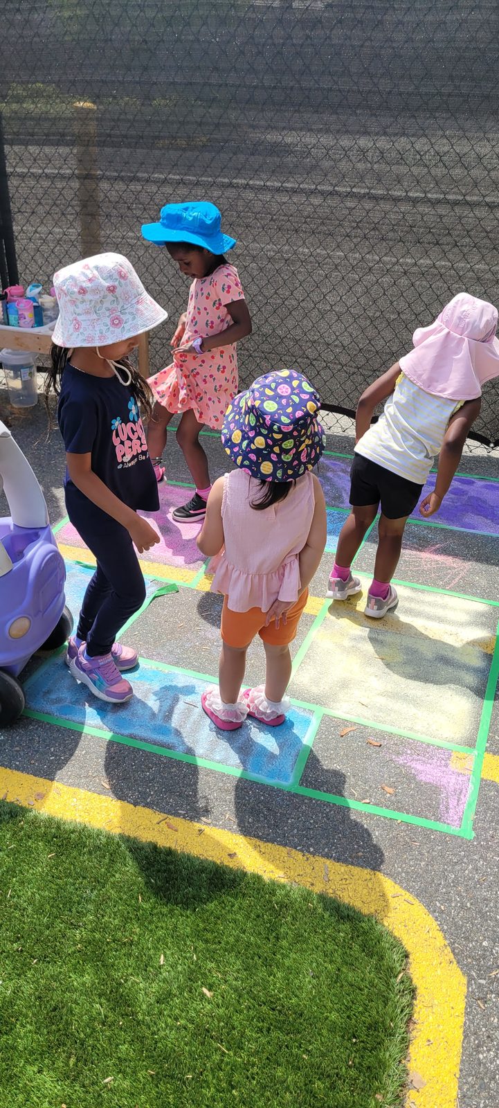 Children playing hopscotch on the painted outdoor court