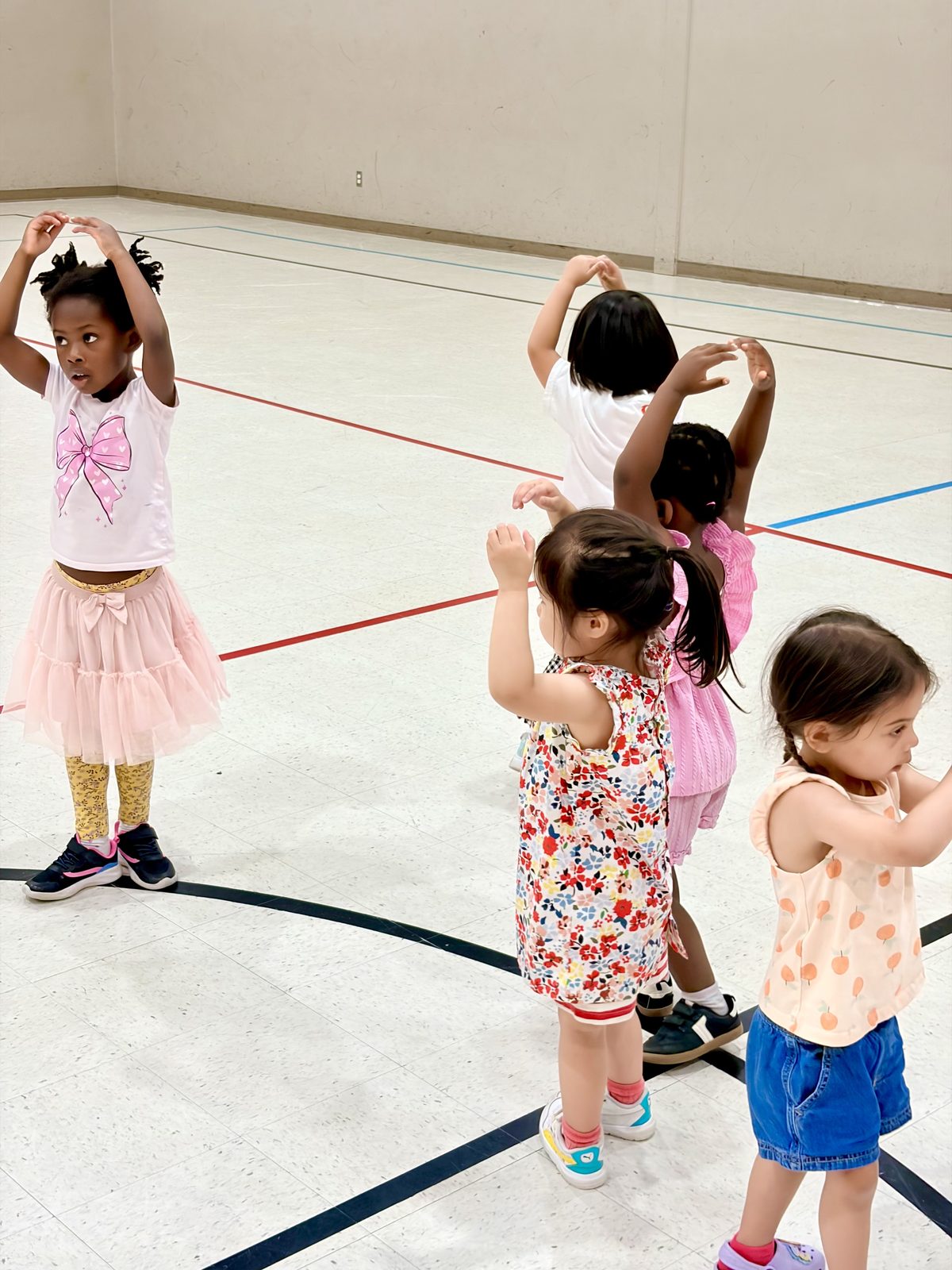 Children raising their arms together during a movement and dance activity