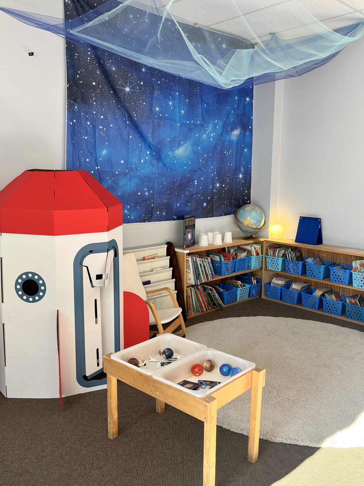 The Wonderful Steps space corner with a cardboard rocket and book library